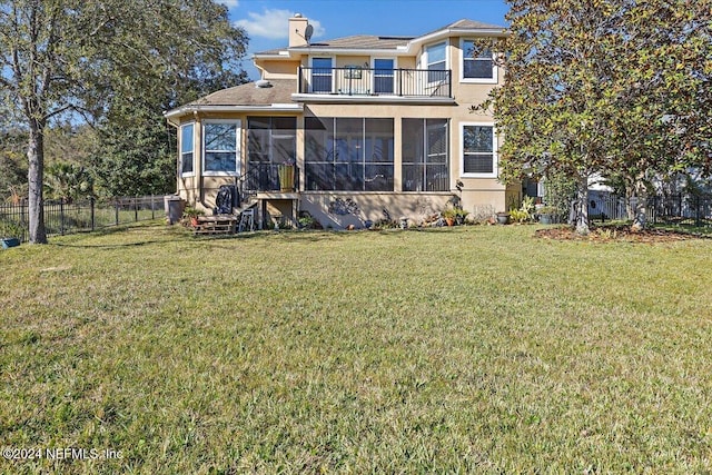 back of house featuring a lawn, a sunroom, and a balcony