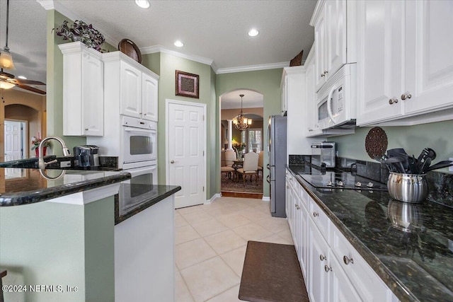 kitchen featuring white appliances, white cabinets, crown molding, light tile patterned floors, and a textured ceiling