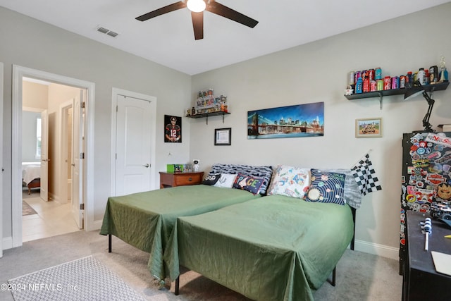 bedroom with ceiling fan, black fridge, and carpet floors