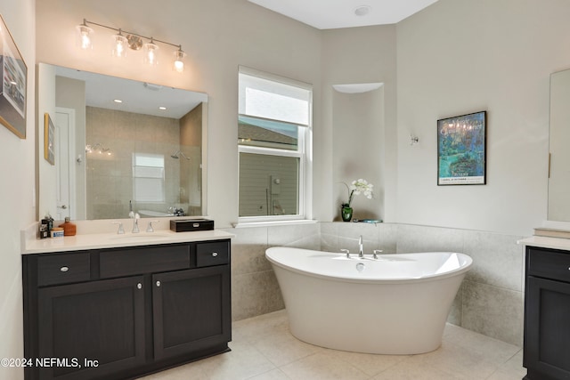 bathroom featuring tile patterned flooring, vanity, tile walls, and independent shower and bath