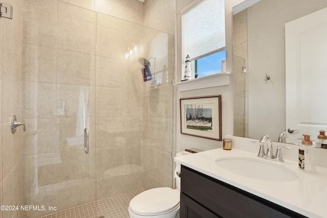 bathroom featuring vanity, toilet, and a shower with door