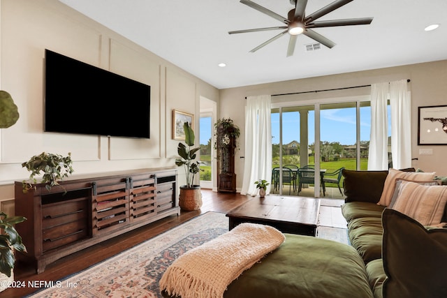 living room with ceiling fan and dark wood-type flooring