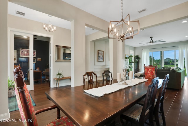 dining room featuring ceiling fan with notable chandelier and dark hardwood / wood-style flooring