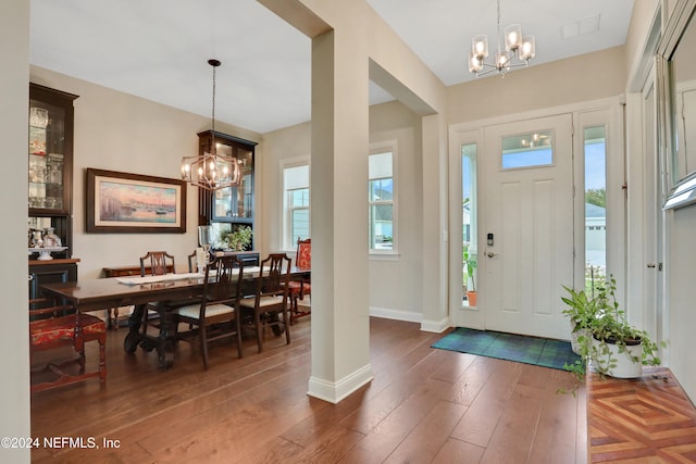 foyer featuring dark hardwood / wood-style floors, an inviting chandelier, and a wealth of natural light