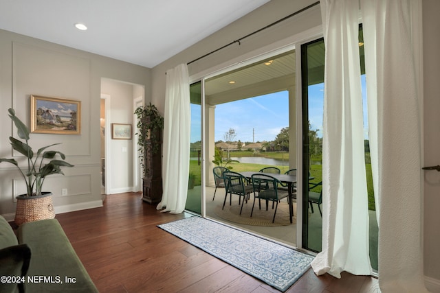 doorway featuring dark hardwood / wood-style flooring and a water view