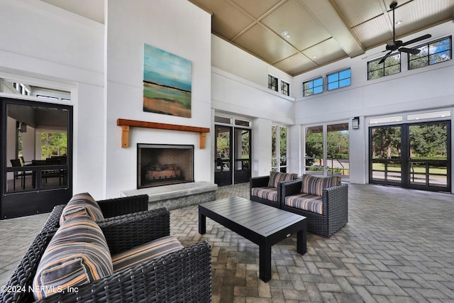 520 Back Creek Dr, Saint Augustine, FL 32092 - living area with a fireplace with raised hearth, a ceiling fan, a towering ceiling, and brick flooring