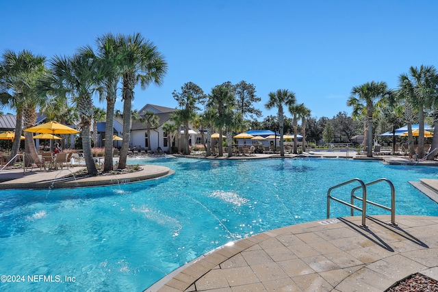 view of swimming pool featuring pool water feature and a patio