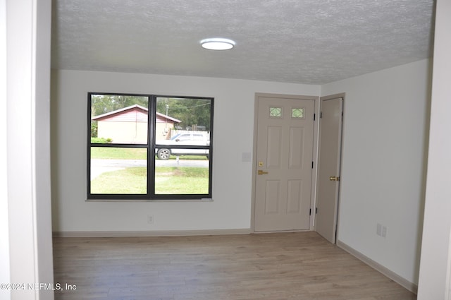 foyer entrance featuring light hardwood / wood-style floors and a textured ceiling