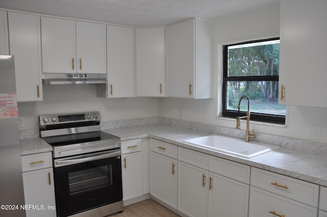 kitchen with white cabinetry, appliances with stainless steel finishes, a textured ceiling, sink, and light hardwood / wood-style floors