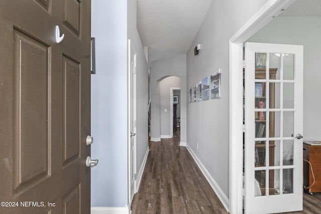 hall with dark wood-type flooring and a textured ceiling