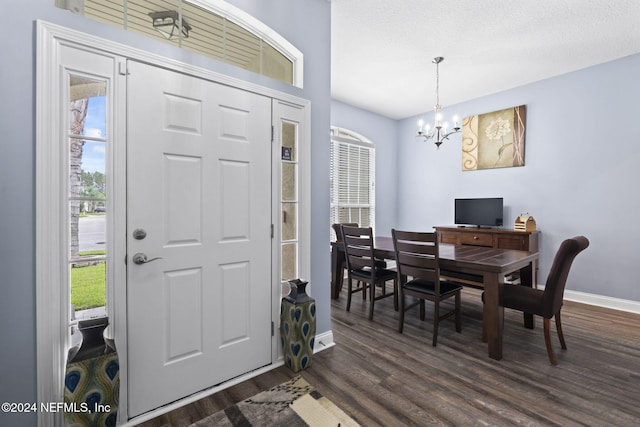 foyer featuring a chandelier, dark wood-type flooring, and a textured ceiling