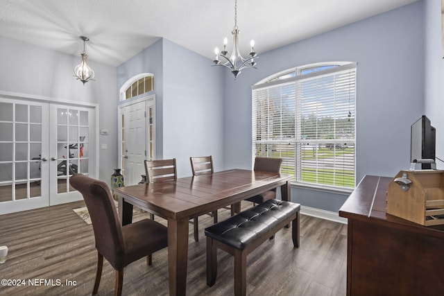 dining space with dark wood-type flooring, french doors, a healthy amount of sunlight, and an inviting chandelier