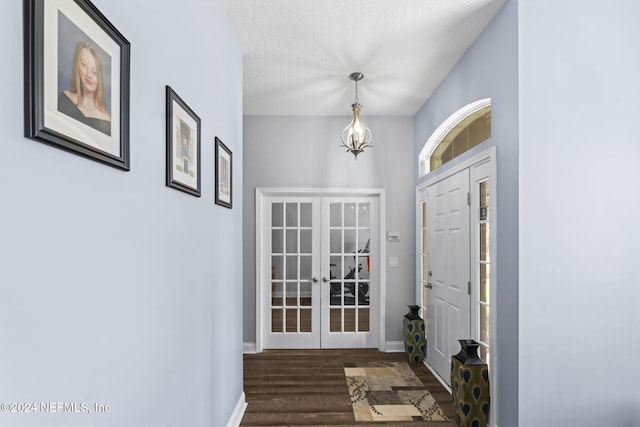 entrance foyer with dark hardwood / wood-style flooring, a textured ceiling, and french doors