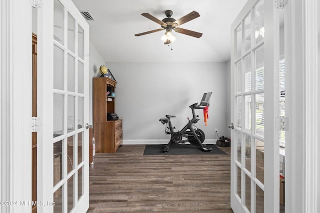 exercise area with ceiling fan, dark hardwood / wood-style flooring, and french doors