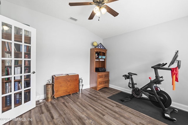 exercise room with ceiling fan, dark wood-type flooring, and lofted ceiling