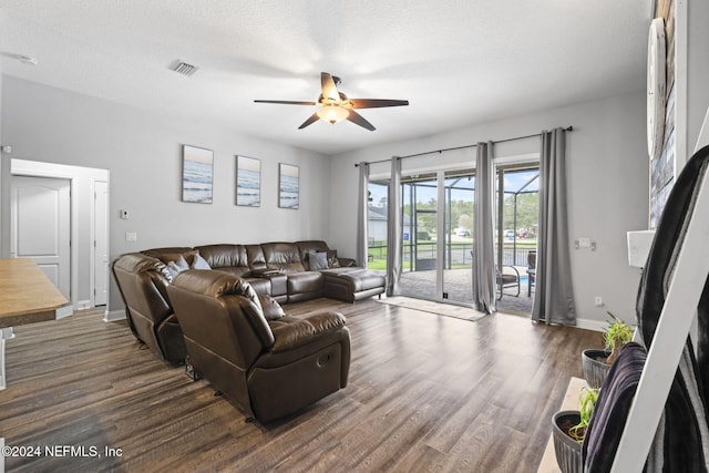 living room with ceiling fan, dark hardwood / wood-style flooring, and a textured ceiling