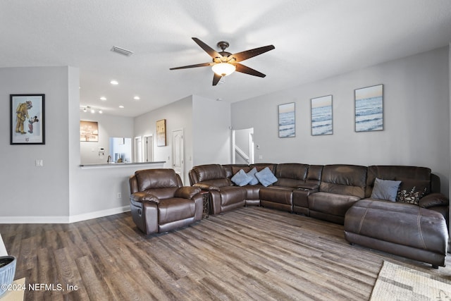 living room with a textured ceiling, hardwood / wood-style flooring, and ceiling fan