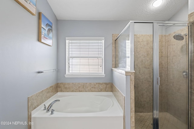 bathroom featuring a textured ceiling and independent shower and bath