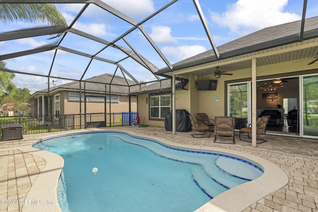 view of swimming pool featuring a lanai, a patio area, and ceiling fan