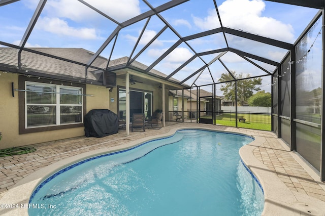 view of pool with a lanai, area for grilling, ceiling fan, and a patio