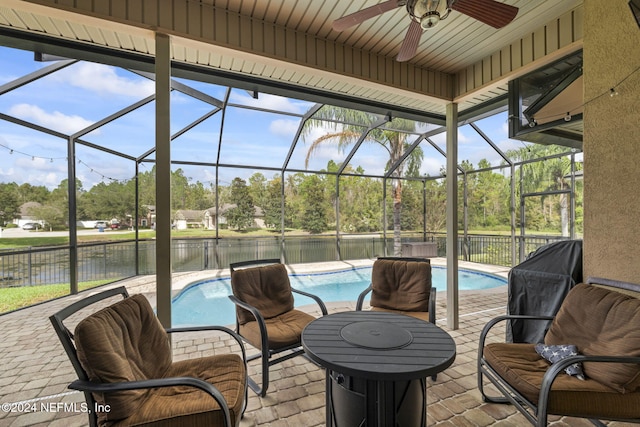 view of patio featuring a lanai, ceiling fan, a fenced in pool, and a water view