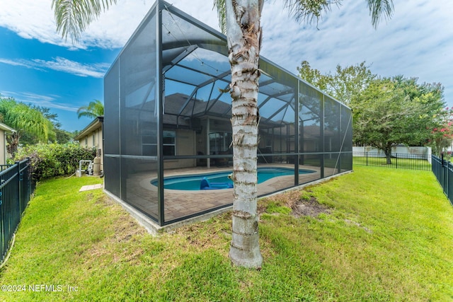 exterior space featuring a fenced in pool, glass enclosure, and a yard