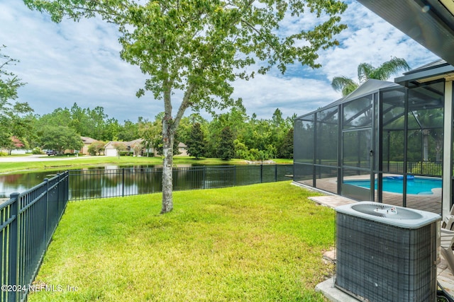 view of yard with a water view, glass enclosure, cooling unit, and a fenced in pool