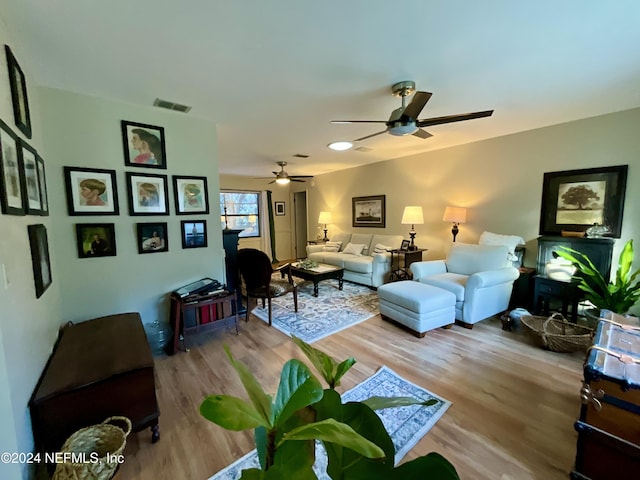 living room with light wood-type flooring and ceiling fan