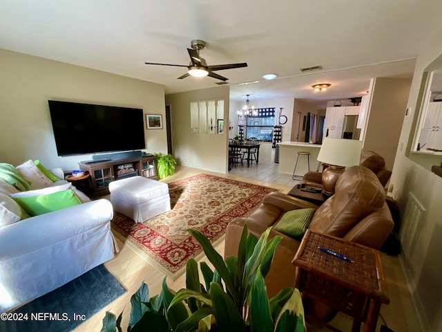 living room with light hardwood / wood-style floors and ceiling fan with notable chandelier