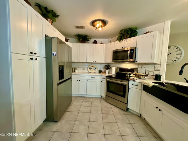 kitchen with decorative backsplash, white cabinetry, and stainless steel appliances