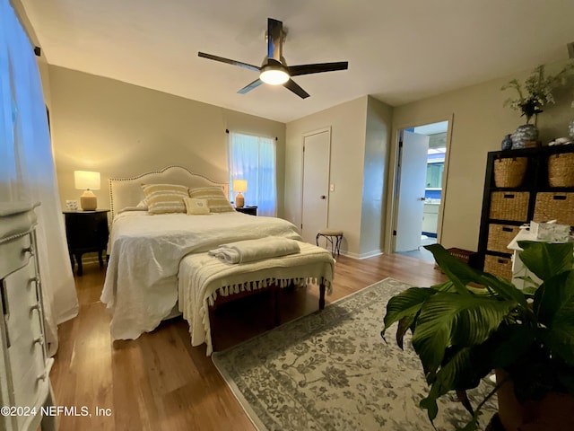 bedroom with ceiling fan, connected bathroom, and light hardwood / wood-style flooring