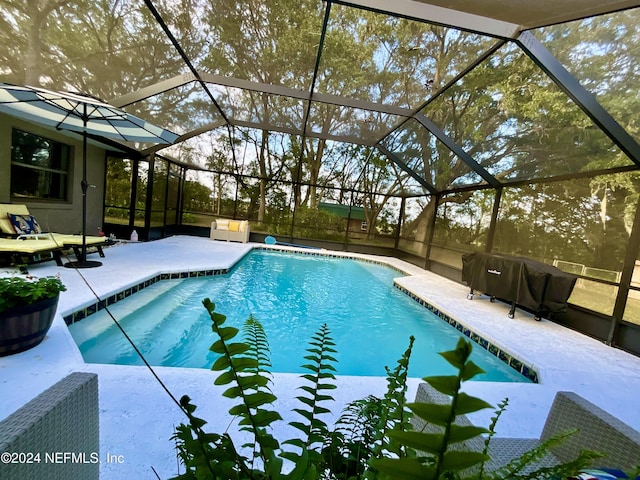 view of swimming pool with glass enclosure and a patio area