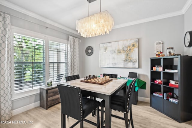 dining room with a notable chandelier, crown molding, and light hardwood / wood-style flooring