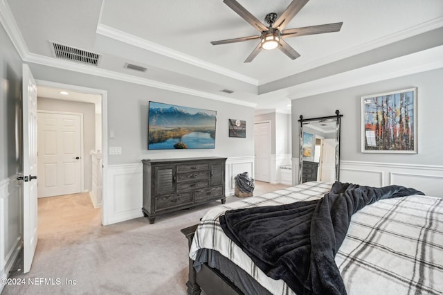 bedroom with a barn door, light colored carpet, ceiling fan, and ornamental molding