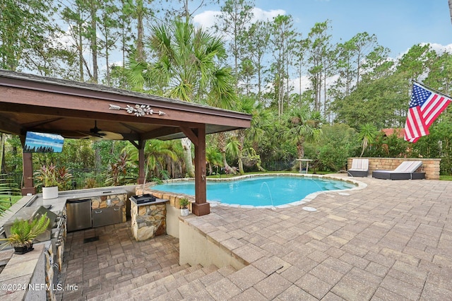 view of pool with area for grilling, ceiling fan, pool water feature, and a patio