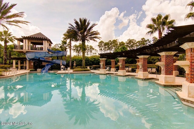 view of pool with exterior fireplace and a water slide