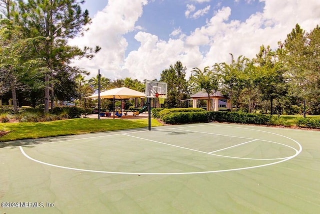 view of basketball court featuring a gazebo, a playground, and a lawn