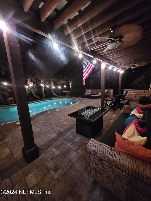 view of pool featuring ceiling fan, a patio, and an outdoor living space with a fire pit