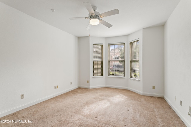 carpeted spare room with ceiling fan