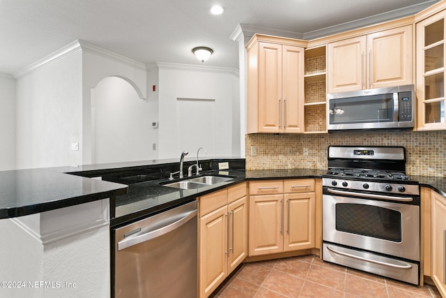 kitchen featuring kitchen peninsula, appliances with stainless steel finishes, decorative backsplash, ornamental molding, and sink