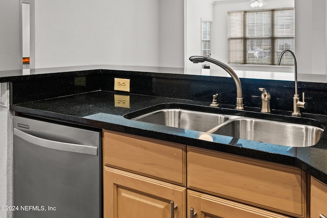 kitchen featuring dishwasher, light brown cabinetry, sink, and dark stone counters