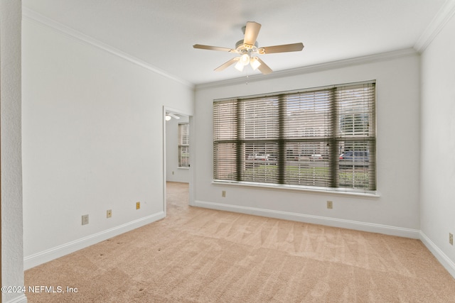 spare room featuring crown molding, ceiling fan, and light colored carpet