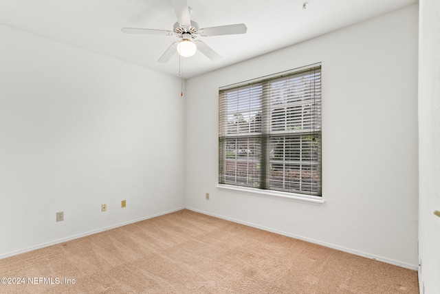 spare room featuring light carpet and ceiling fan