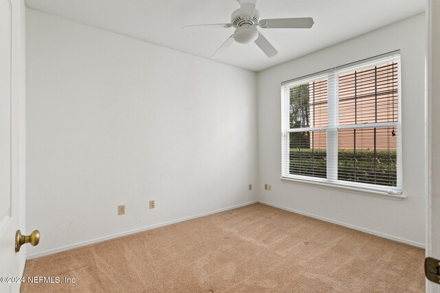 spare room with light carpet and ceiling fan