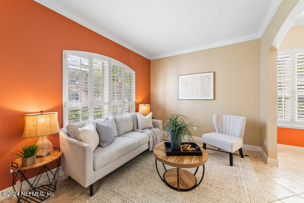 living room with tile patterned floors and crown molding