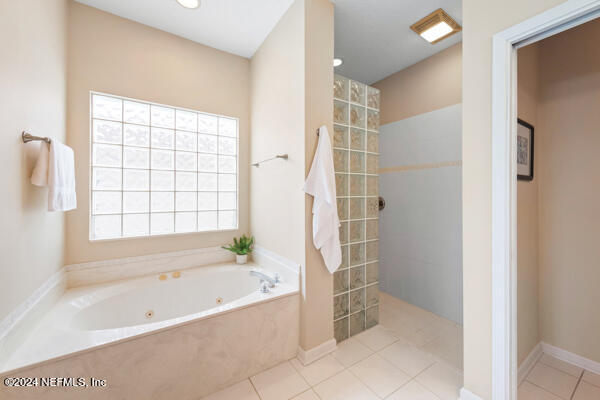 bathroom with separate shower and tub and tile patterned flooring