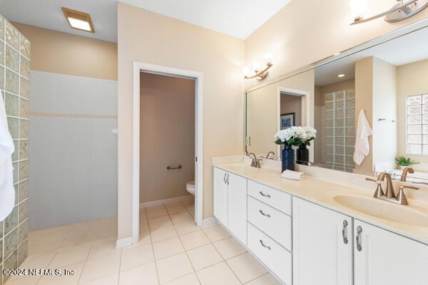 bathroom featuring tile patterned floors, a shower, vanity, and toilet