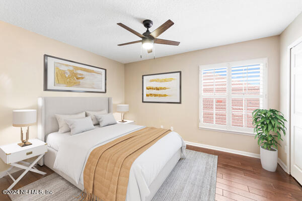 bedroom featuring ceiling fan, dark hardwood / wood-style flooring, and a textured ceiling