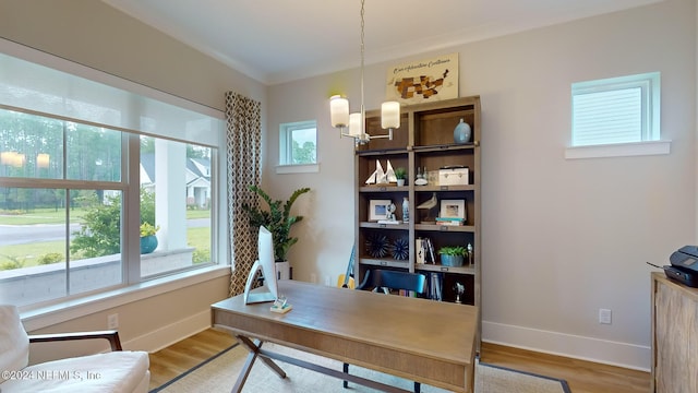 office with a notable chandelier, light wood-style flooring, and baseboards