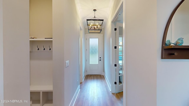 interior space featuring light wood-type flooring, baseboards, and an inviting chandelier